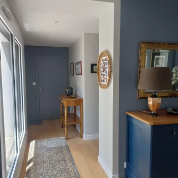 Entrée avec mur bleu-gris, meuble bleu et miroir doré