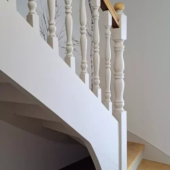 Escalier avec balustres blancs et main courante en bois