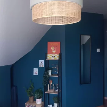 Espace sous escalier peint en bleu canard avec suspension en rotin