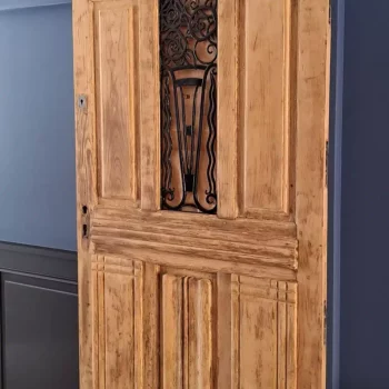 Porte coulissante en bois ancien sur un mur peint en bleu