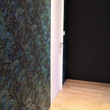 Couloir avec papier peint végétal et mur peint en noir