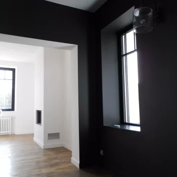Pièce de vie avec murs peints en noir mat et encadrement blanc