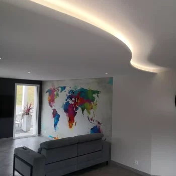 Salon avec faux plafond et éclairage indirect, papier peint carte du monde