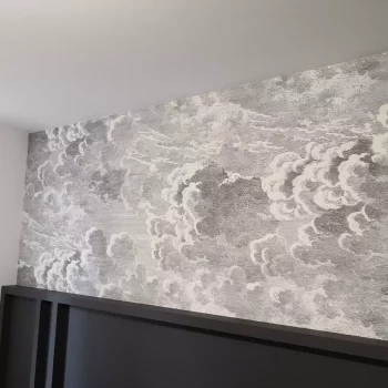 Mur tapissé d'un papier peint nuages au-dessus d'un soubassement noir