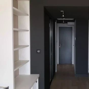 Couloir peint en gris anthracite avec bibliothèque blanche intégrée